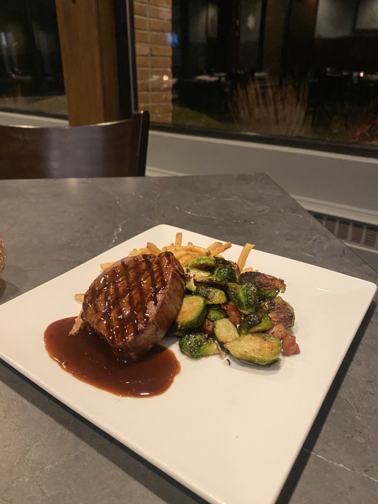 Photo of our 7oz Filet Mignon with pancetta brussels sprouts and rosemary parmesan pommes frites